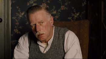 Movie still from “Vera Drake” (2004), directed by Mike Leigh – An older man sitting on a couch in a living room; Close Up shot, Low angle
