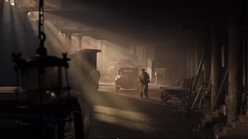 Movie still from “Vera Drake” (2004), directed by Mike Leigh – A man standing in the middle of an industrial area; Extreme Wide shot, High angle