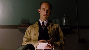 Movie still from “Vera Drake” (2004), directed by Mike Leigh – A man holding a pen and paper in his hands; Close Up shot, Low angle