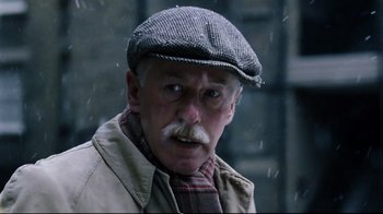 Movie still from “Vera Drake” (2004), directed by Mike Leigh – An old man with a mustache wearing a hat; Close Up shot, Low angle