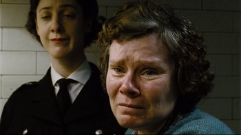 Movie still from “Vera Drake” (2004), directed by Mike Leigh – A woman in a suit and tie looking sad; Close Up shot, Low angle