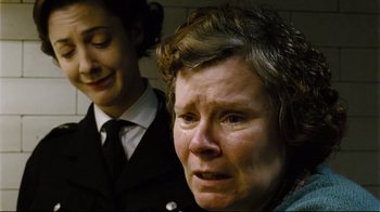 Movie still from “Vera Drake” (2004), directed by Mike Leigh – A woman crying next to another woman in a suit; Close Up shot, Low angle