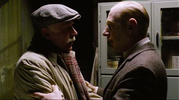 Movie still from “Vera Drake” (2004), directed by Mike Leigh – Two older men are standing together and one is wearing a tie; Close Up shot, Low angle