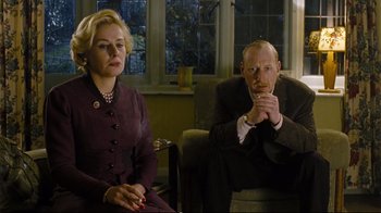 Movie still from “Vera Drake” (2004), directed by Mike Leigh – A man and a woman sitting on a chair; Medium shot, Low angle