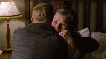 Movie still from “Vera Drake” (2004), directed by Mike Leigh – An older man hugging a younger woman in front of a bed; Close Up shot, High angle