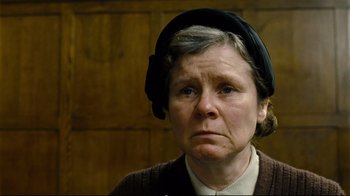 Movie still from “Vera Drake” (2004), directed by Mike Leigh – An older woman wearing a black hat and a brown jacket; Close Up shot, Low angle