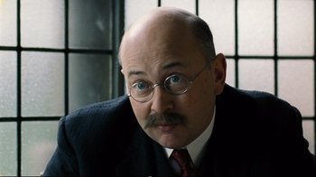 Movie still from “Vera Drake” (2004), directed by Mike Leigh – An older man with a mustache wearing a suit; Close Up shot, Over the shoulder angle