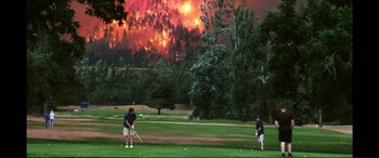 Movie still from “Vice” (2018), directed by Adam McKay – Two people playing golf on a golf course; Extreme Wide shot, High angle