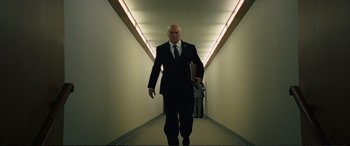 Movie still from “Vice” (2018), directed by Adam McKay – A man in a suit and tie walking down a hallway; Medium shot, Low angle