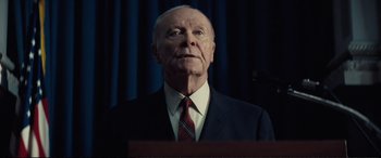 Movie still from “Vice” (2018), directed by Adam McKay – An older man wearing a suit and tie; Close Up shot, Low angle