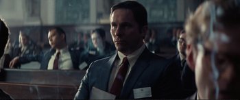 Movie still from “Vice” (2018), directed by Adam McKay – A man in a suit and tie holding a paper; Close Up shot, Low angle