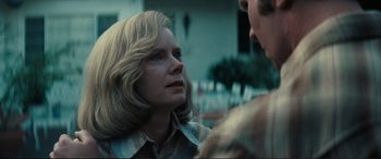 Movie still from “Vice” (2018), directed by Adam McKay – A woman is looking at a man in a plaid shirt; Close Up shot, Over the shoulder angle