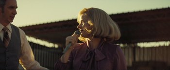 Movie still from “Vice” (2018), directed by Adam McKay – A woman in a purple shirt is holding a microphone; Medium shot, Low angle