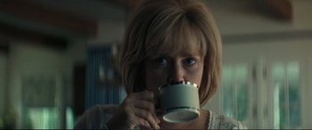 Movie still from “Vice” (2018), directed by Adam McKay – A woman is drinking a cup of coffee; Close Up shot, Over the shoulder angle