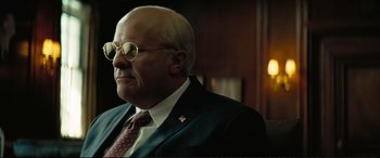 Movie still from “Vice” (2018), directed by Adam McKay – An older man wearing a suit and tie; Close Up shot, Over the shoulder angle