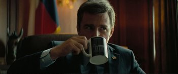 Movie still from “Vice” (2018), directed by Adam McKay – A man holding a coffee mug up to his mouth; Close Up shot, Over the shoulder angle