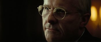Movie still from “Vice” (2018), directed by Adam McKay – An older man wearing glasses looking off into the distance; Close Up shot, Low angle