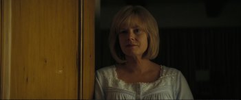 Movie still from “Vice” (2018), directed by Adam McKay – A woman in a white dress is standing in front of a window; Close Up shot, Over the shoulder angle