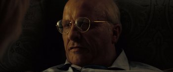 Movie still from “Vice” (2018), directed by Adam McKay – An older man wearing glasses and a bow tie; Close Up shot, Low angle