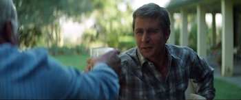 Movie still from “Vice” (2018), directed by Adam McKay – A man holding a glass in his right hand; Close Up shot, Over the shoulder angle