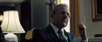 Movie still from “Vice” (2018), directed by Adam McKay – An older man wearing a suit and tie; Close Up shot, Low angle