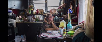 Movie still from “Vice” (2018), directed by Adam McKay – A woman sitting at a table in front of a board game; Medium shot, Over the shoulder angle