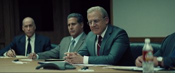 Movie still from “Vice” (2018), directed by Adam McKay – Two men in suits sitting at a conference table; Medium shot, Over the shoulder angle
