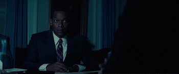 Movie still from “Vice” (2018), directed by Adam McKay – A man sitting at a table in front of a window; Medium shot, Over the shoulder angle