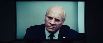 Movie still from “Vice” (2018), directed by Adam McKay – A person wearing a suit and tie; Close Up shot, Over the shoulder angle