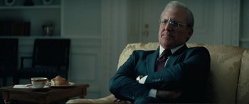 Movie still from “Vice” (2018), directed by Adam McKay – An older man sitting in a chair with his arms crossed; Close Up shot, Over the shoulder angle