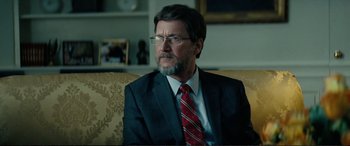 Movie still from “Vice” (2018), directed by Adam McKay – A person wearing a suit and tie; Close Up shot, Over the shoulder angle