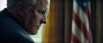 Movie still from “Vice” (2018), directed by Adam McKay – An older man wearing glasses looking out a window; Close Up shot, Over the shoulder angle