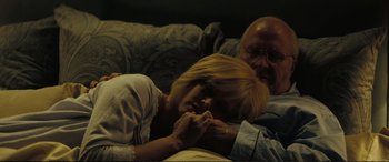 Movie still from “Vice” (2018), directed by Adam McKay – An older man and a younger woman laying on a couch; Medium shot, High angle