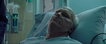 Movie still from “Vice” (2018), directed by Adam McKay – An older man laying in a hospital bed with his eyes closed; Close Up shot, Low angle