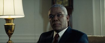 Movie still from “Vice” (2018), directed by Adam McKay – A man in a suit and tie with glasses; Close Up shot, Low angle
