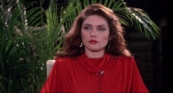 Movie still from “Videodrome” (1983), directed by David Cronenberg – A person wearing a red shirt; Close Up shot, Over the shoulder angle