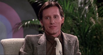 Movie still from “Videodrome” (1983), directed by David Cronenberg – A person wearing a suit and tie; Close Up shot, Low angle