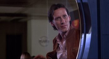 Movie still from “Videodrome” (1983), directed by David Cronenberg – A man looking into a mirror in front of a mirror; Close Up shot, Low angle