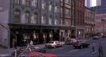 Movie still from “Videodrome” (1983), directed by David Cronenberg – A street scene with cars parked on the side of the road; Extreme Wide shot, High angle
