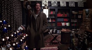 Movie still from “Videodrome” (1983), directed by David Cronenberg – A man standing in front of a book shelf; Medium shot, Low angle
