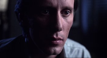 Movie still from “Videodrome” (1983), directed by David Cronenberg – A man's face in the dark; Close Up shot, Low angle