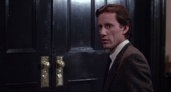 Movie still from “Videodrome” (1983), directed by David Cronenberg – A man standing in front of a black door; Close Up shot, Over the shoulder angle