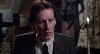 Movie still from “Videodrome” (1983), directed by David Cronenberg – A person wearing a suit and tie; Close Up shot, Low angle