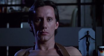 Movie still from “Videodrome” (1983), directed by David Cronenberg – A person wearing a brown shirt; Close Up shot, Low angle