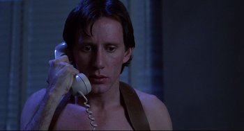 Movie still from “Videodrome” (1983), directed by David Cronenberg – A man holding a phone up to his ear; Close Up shot, Low angle
