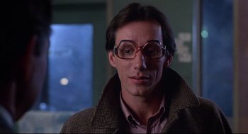 Movie still from “Videodrome” (1983), directed by David Cronenberg – A person wearing glasses and a jacket; Close Up shot, Low angle