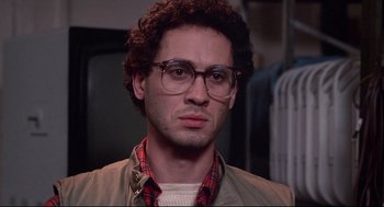 Movie still from “Videodrome” (1983), directed by David Cronenberg – A person wearing glasses and a jacket; Close Up shot, Low angle