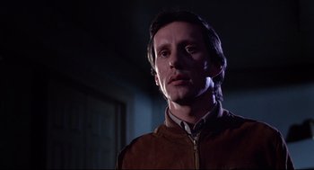 Movie still from “Videodrome” (1983), directed by David Cronenberg – A person wearing a brown jacket; Close Up shot, Low angle