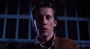 Movie still from “Videodrome” (1983), directed by David Cronenberg – A person wearing a brown jacket; Close Up shot, Low angle