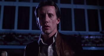 Movie still from “Videodrome” (1983), directed by David Cronenberg – A person wearing a leather jacket; Close Up shot, Low angle